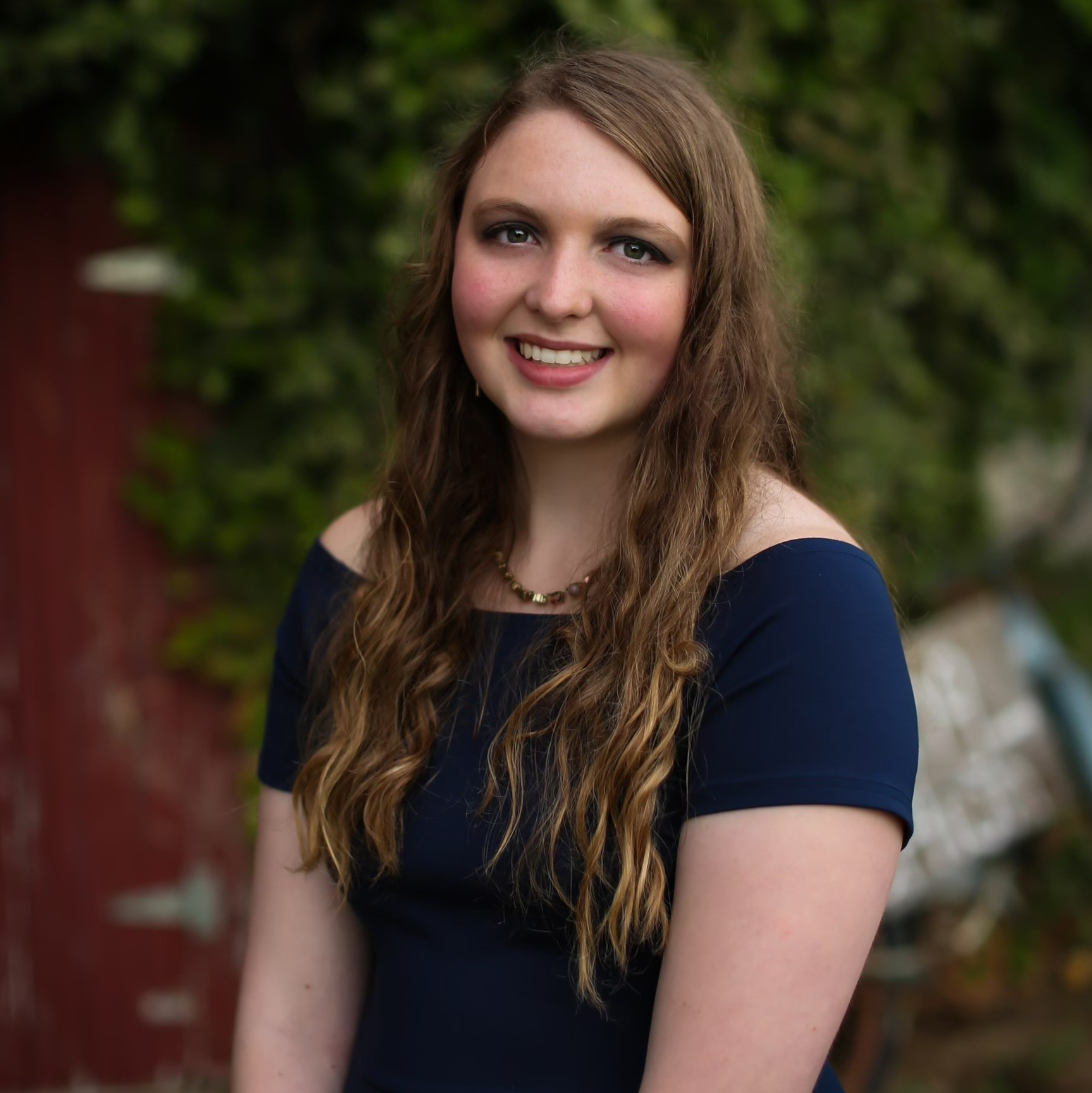 White female in a blue dress smiling