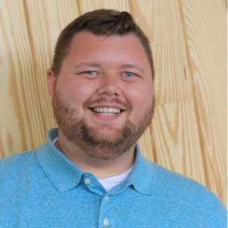 Male in a blue sweater against a beige background
