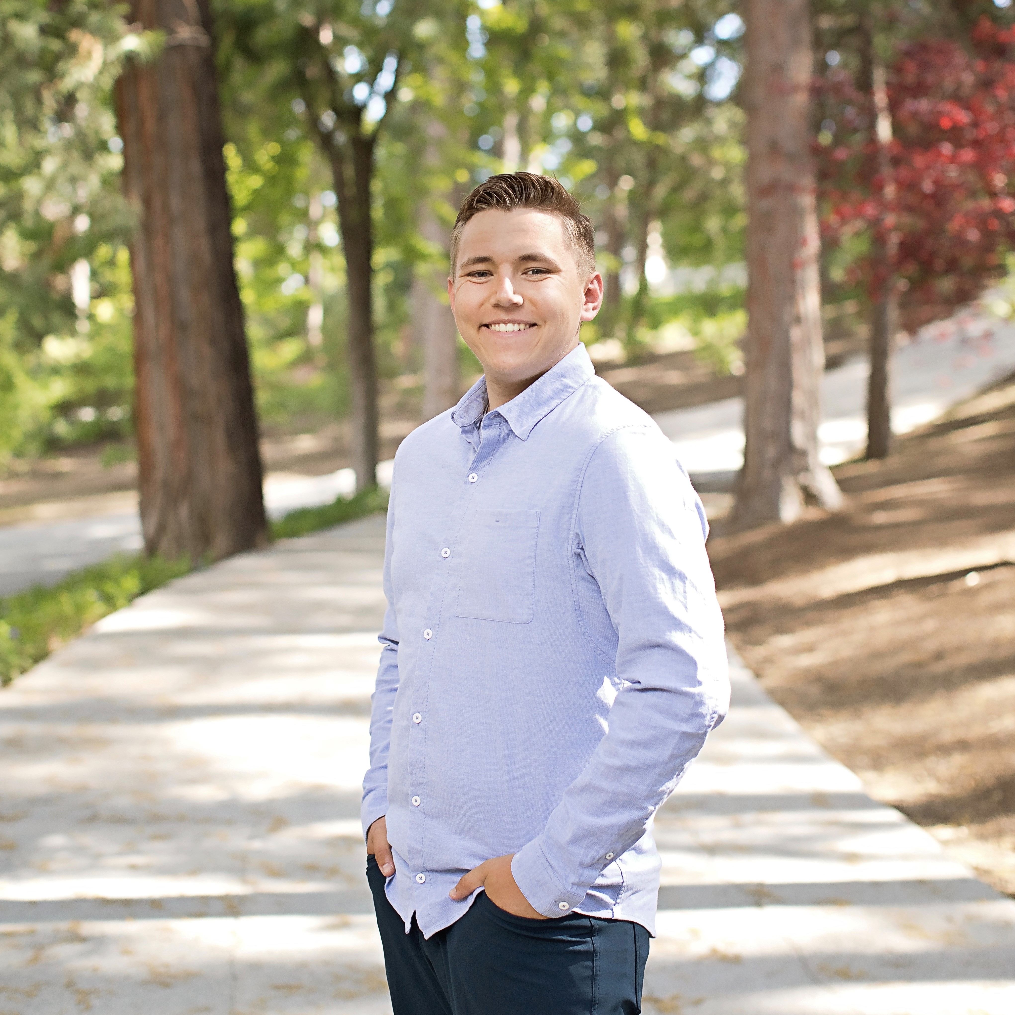 White male in a light colored shirt with a landscape background