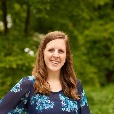 A white female in a blue blouse with a green background